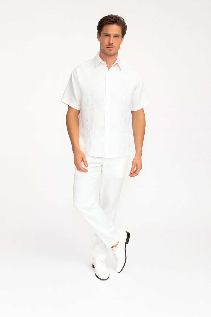 Men's white two-piece guayabera set: short-sleeve embroidered shirt and straight-cut pants. Lightweight fabric with detailed embroidery on the shirt, tailored for a cohesive look.
