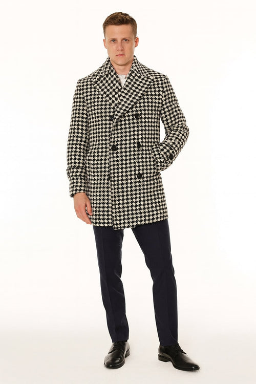 Men's houndstooth double-breasted overcoat. Black and white wool blend. Structured silhouette, broad lapel. Features houndstooth pattern, two front pockets, and six-button closure.
