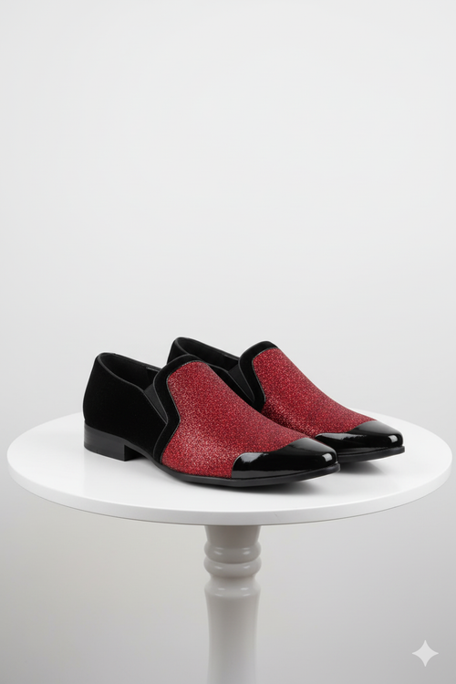 Red glitter tuxedo loafers for men. Shiny, slip-on design with a black patent leather toe and glittery red upper. Matte black fabric sides. Low, solid heel.
