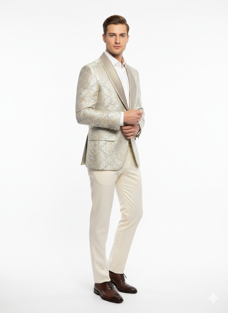 Men's luxury blazer with champagne silver & cream floral pattern on a tan base. Structured shape, embroidered details, contrasting collar. Paired with light tan trousers.
