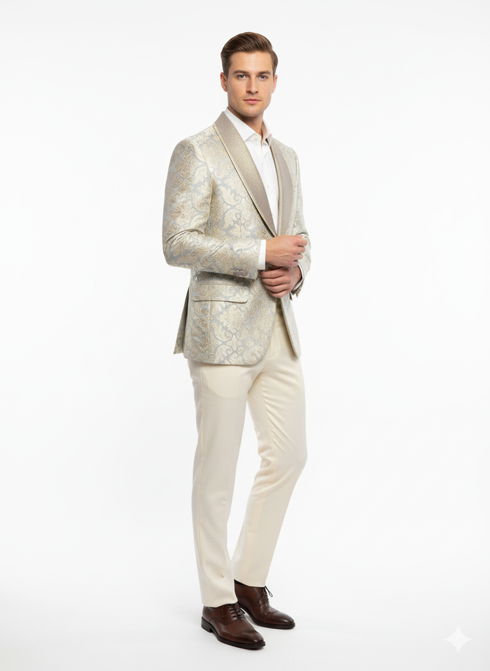 Men's luxury blazer with champagne silver & cream floral pattern on a tan base. Structured shape, embroidered details, contrasting collar. Paired with light tan trousers.
