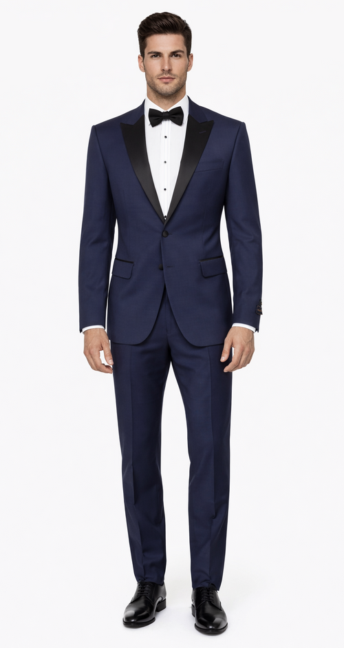 Navy blue tuxedo with peak lapel. Smooth fabric, button closure, and two front pockets. Sharp lines create a fitted look inspired by The Great Gatsby era.
