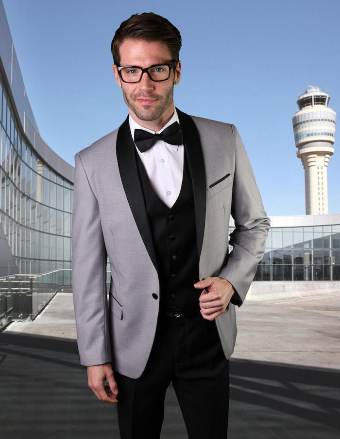 Grey wool-blend men's tuxedo with shawl lapel. Tailored single-breasted design, black lapel, three-button closure. Includes black vest and white dress shirt for a formal look.
