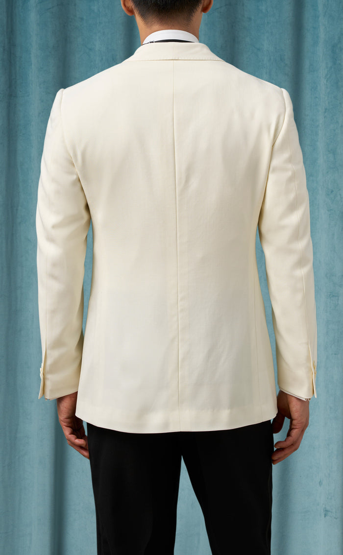 Men's ivory dinner jacket: tailored, single vent, long sleeves. Smooth, matte, light cream fabric. Standard lapel, button closure. Minimalist design, no patterns.

