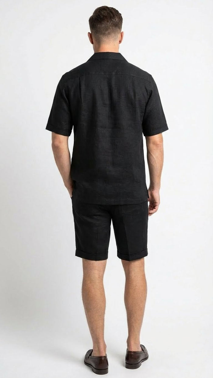 Men's black walking suit featuring a short-sleeved shirt and matching shorts. The shirt has a relaxed fit with a classic collar, and the shorts are tailored with a rolled cuff. Both pieces are made of a lightweight, textured fabric that appears breathable.