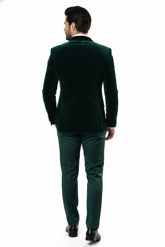 Men's dark green velvet tuxedo: fitted, single-breasted jacket paired with matching trousers. Plush, subtly shimmering fabric for an elegant look.
