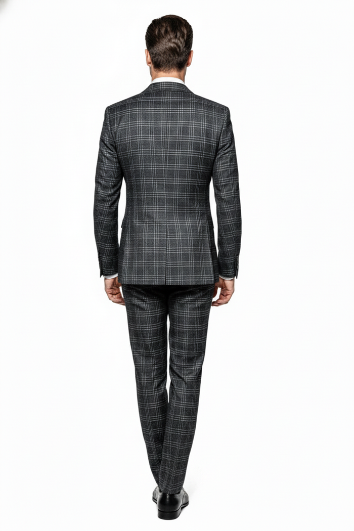 Charcoal plaid double-breasted suit: structured blazer with notched collar, two rows of buttons, and matching tailored trousers. Dark charcoal base with light gray plaid. Sleek silhouette.

