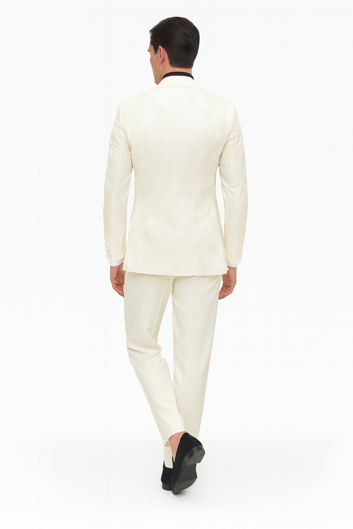 Ivory men's tuxedo jacket with floral embroidery, black collar, and matching ivory pants. Structured fit with an intricate floral pattern.
