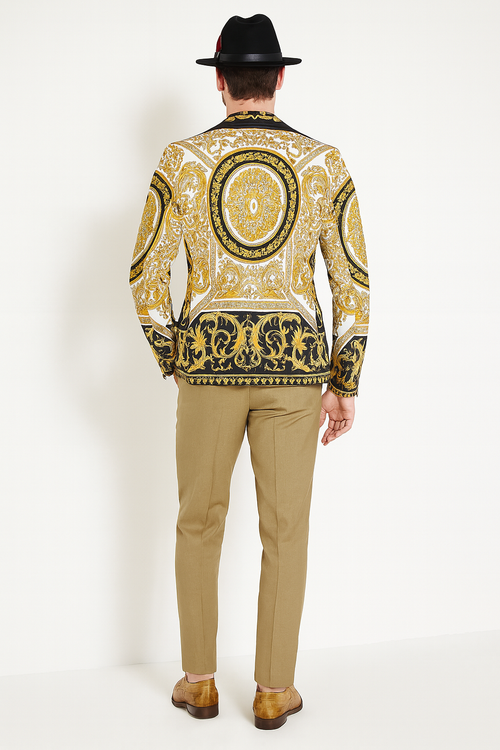 Black and gold baroque blazer with ornate patterns, beige pants, and brown shoes. Includes a black hat. Elegant men's outfit.
