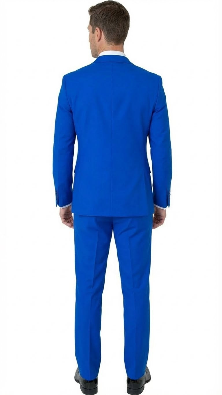 Royal blue men's tuxedo suit with embellishments, structured fit, and single vent. Includes matching tailored trousers. Lapel details enhance the design. Paired with a contrasting white shirt (collar visible).
