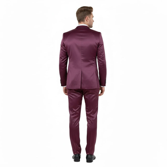 Burgundy sateen tuxedo: slim fit, shiny finish. Features satin shawl lapel jacket with tailored fit, structured shoulders, and single vent. Matching slim trousers. Smooth, glossy texture emphasizes formal design.
