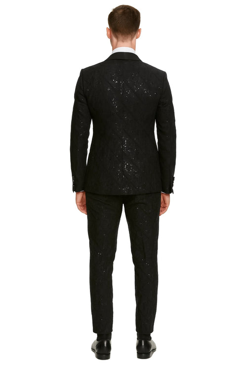 Black sequin tuxedo suit with satin shawl lapel. Tailored fit, quilted back, slim pants. Sparkling fabric and cohesive design.
