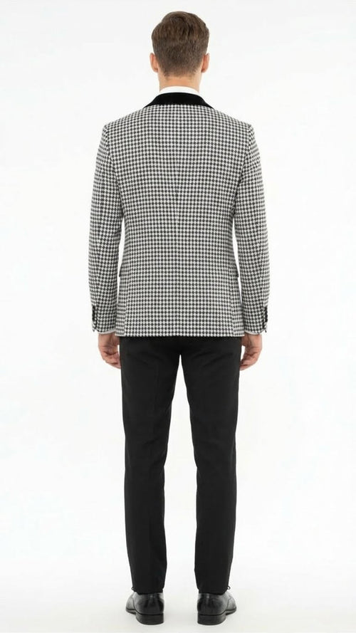 Men's black & white houndstooth tuxedo set: patterned blazer w/ velvet shawl lapel, paired w/ solid black trousers. Blazer features structured fit and contrasting lapel.
