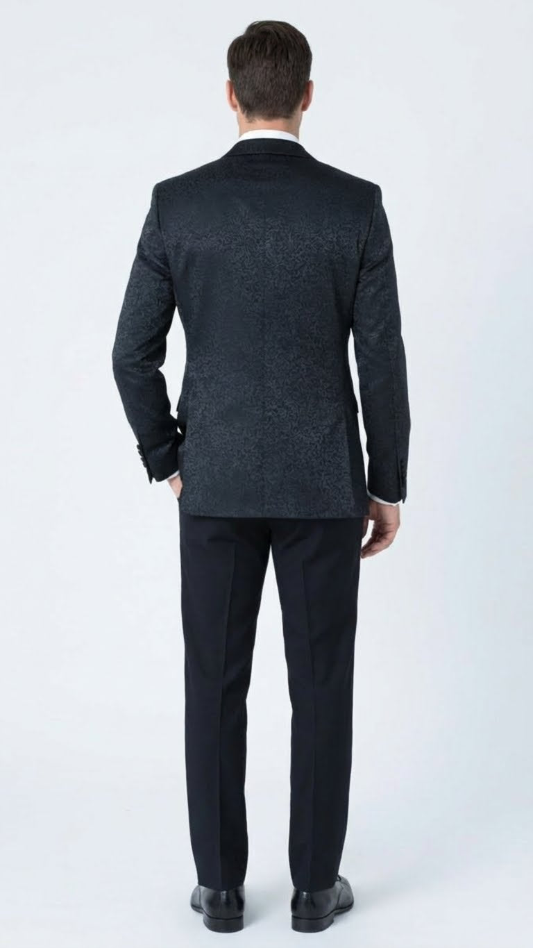 Men's black tuxedo suit with textured paisley floral pattern. Slim-fit jacket, patterned back, smooth lapels, single vent. Tailored trousers match the jacket.
