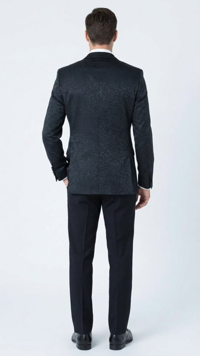 Men's black tuxedo suit with textured paisley floral pattern. Slim-fit jacket, patterned back, smooth lapels, single vent. Tailored trousers match the jacket.
