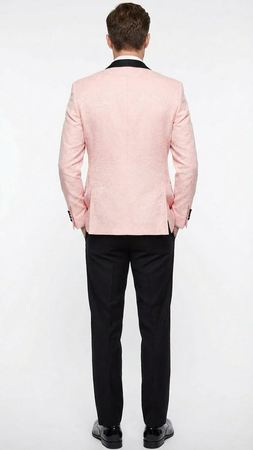 Men's blush pink tuxedo suit: textured jacket with black shawl lapel & single vent. Black straight-leg trousers. Elegant, tailored fit.
