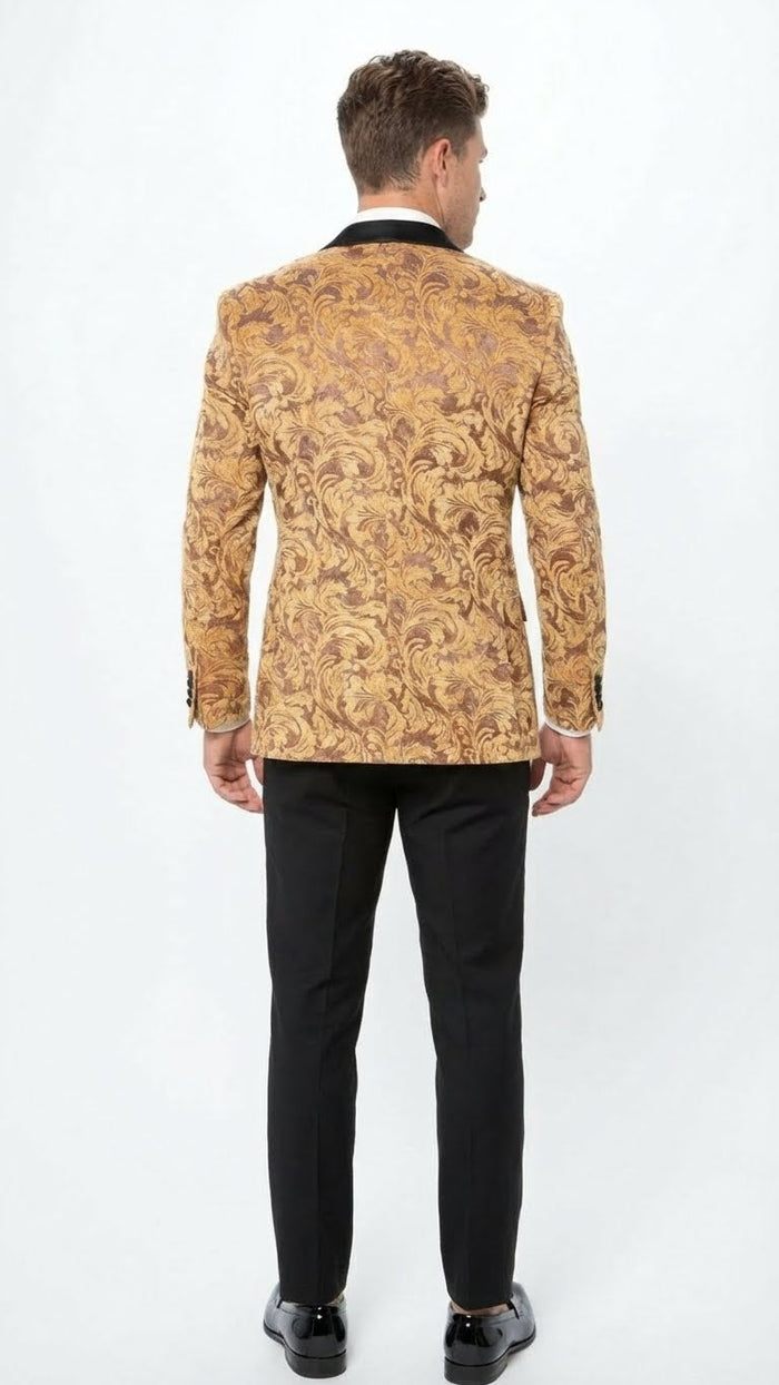 Yellow gold baroque tuxedo blazer. Fitted silhouette, two-button closure, notched lapels. Intricate gold and darker tone pattern. Paired with black trousers for contrast.
