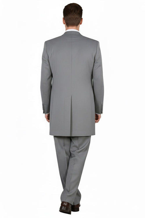 Light gray three-piece zoot suit. Smooth fabric. Long jacket with a single back vent and detailed stitching. Vest and straight-leg trousers complete the formal, tailored look.
