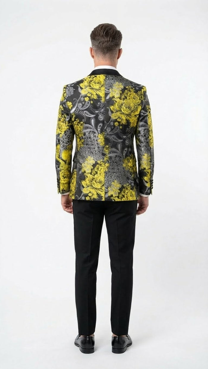 Yellow tuxedo with black and gold floral blazer. Tailored fit, black lapel. Large yellow flowers on dark, patterned background. Paired with fitted black trousers. Jacket extends to lower back.
