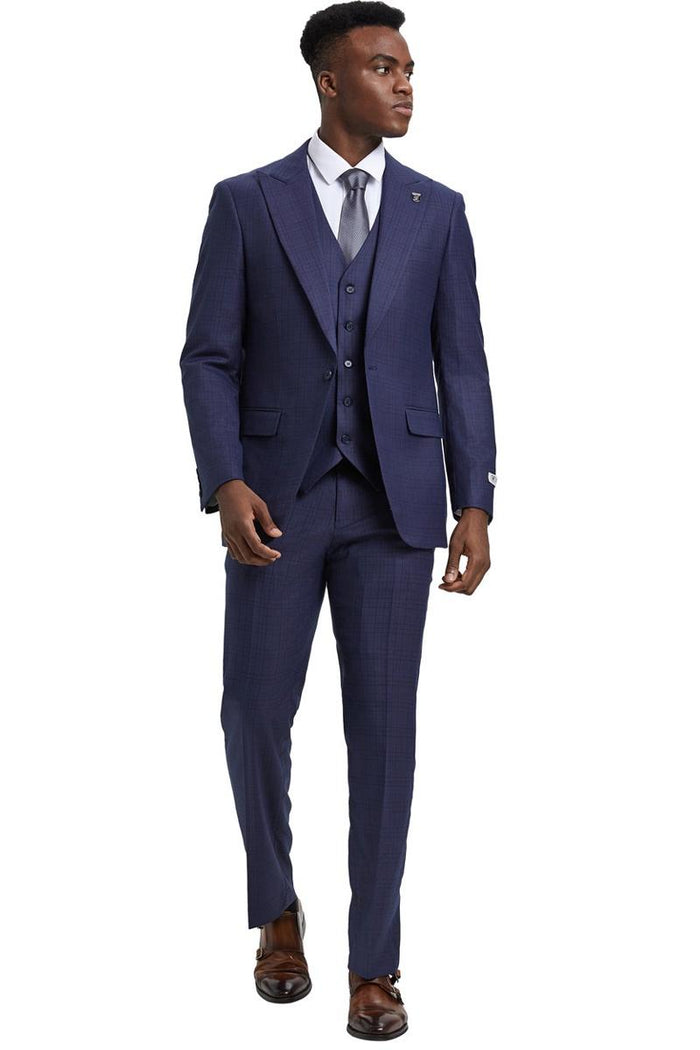 Stacy Adams men's one-button suit with a wide peak lapel, windowpane plaid in eggplant purple. Features a vest, straight-leg trousers, and jacket with small pockets. Made from a fabric blend. Three-piece design.
