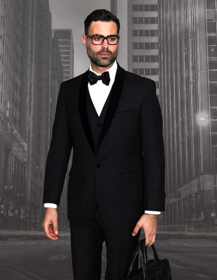 Elegant men's black wool tuxedo with velvet shawl lapel. Fitted silhouette, solid black, smooth texture. Includes vest, white shirt, and bow tie. Matching trousers complete the classic, pattern-free ensemble.
