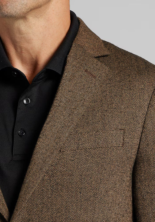 Alberto Nardoni's 1905 sportcoat: brown herringbone, tailored fit, structured design. Textured fabric, sharp lapels, single breast pocket, worn over a black shirt.