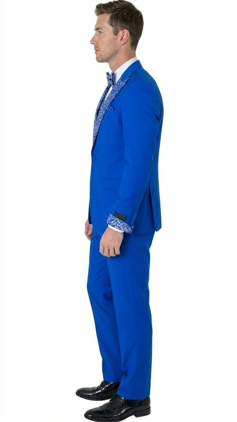 Men's royal blue tuxedo suit with a fitted silhouette. Jacket has an embellished lapel & contrast cuffs. Trousers match the bright blue for a uniform look.
