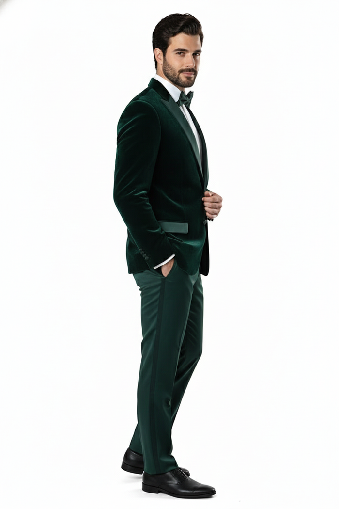 Dark green velvet tuxedo jacket with a fitted shape, peak lapels, and black satin shawl collar. Single-breasted, tailored sleeves with button detail. Sleek, structured design for a close fit.
