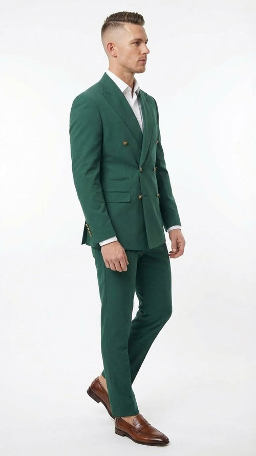 Emerald green double-breasted suit composed of a sleek fabric. The jacket features two rows of buttons and flap pockets, while the trousers are tailored with a straight cut.