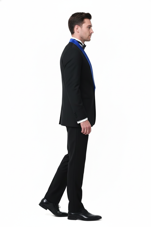 Men's black tuxedo: fitted silhouette, royal blue shawl lapel. Smooth fabric, classic black bow tie. Tailored trousers complete the formal ensemble.
