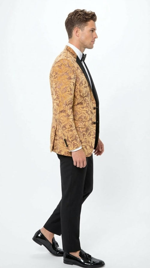 Yellow gold baroque tuxedo blazer with swirling gold/brown patterns. Fitted, single-breasted, notch lapel, buttoned long sleeves. Paired with black trousers. Textured fabric.
