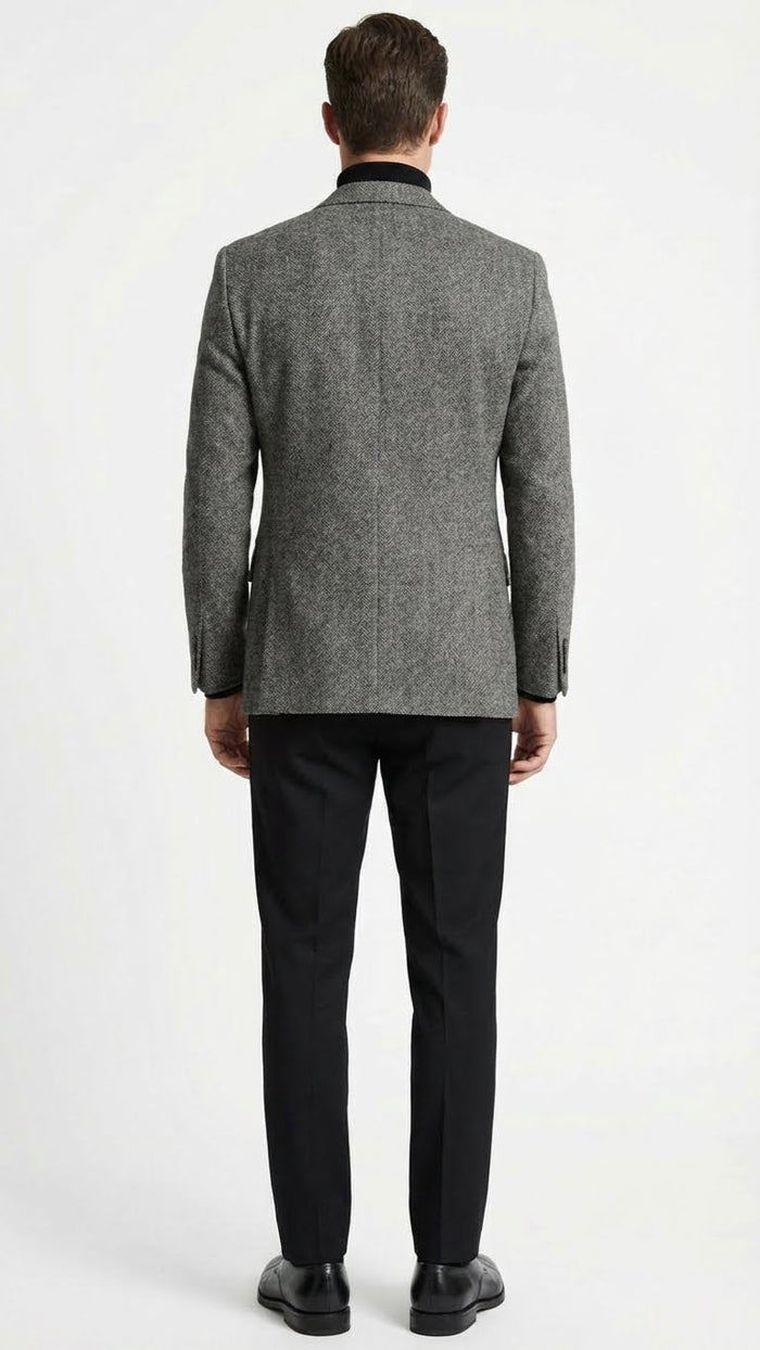 Men's grey tweed herringbone sport coat. Structured design with single vent, long sleeves, and straight waist. Classic grey herringbone pattern, black collar.
