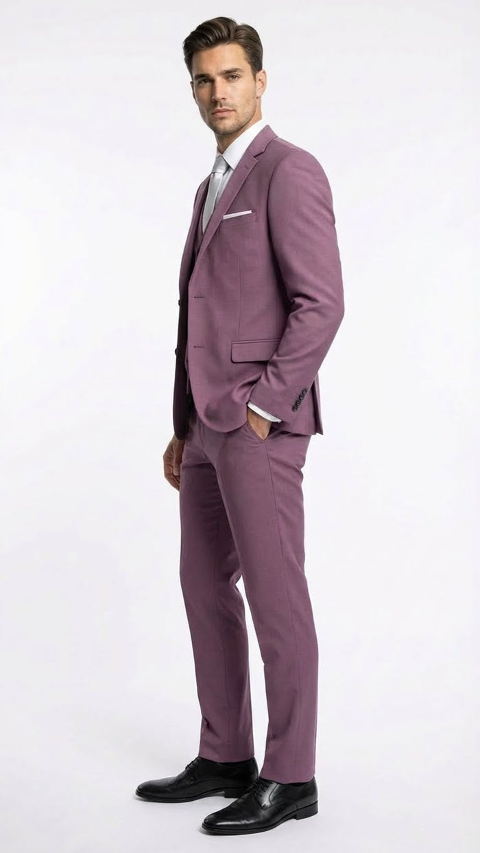 Mauve three-piece men's suit: slim fit blazer (structured shoulders, single-breasted), vest (V-neck), and trousers (straight legs). All in a consistent mauve, textured fabric. Formal.
