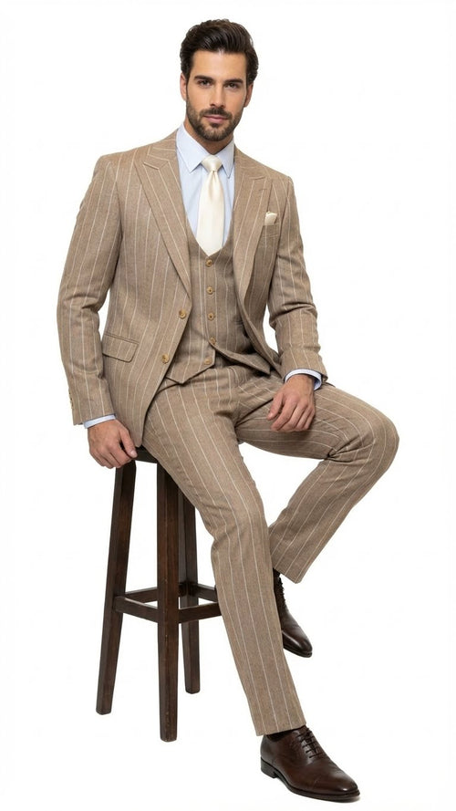 Men's beige pinstripe three-piece suit. Features fitted jacket with golden buttons, matching trousers, and vest. Includes a light blue shirt and cream tie. Tailored fit with vertical stripe pattern.
