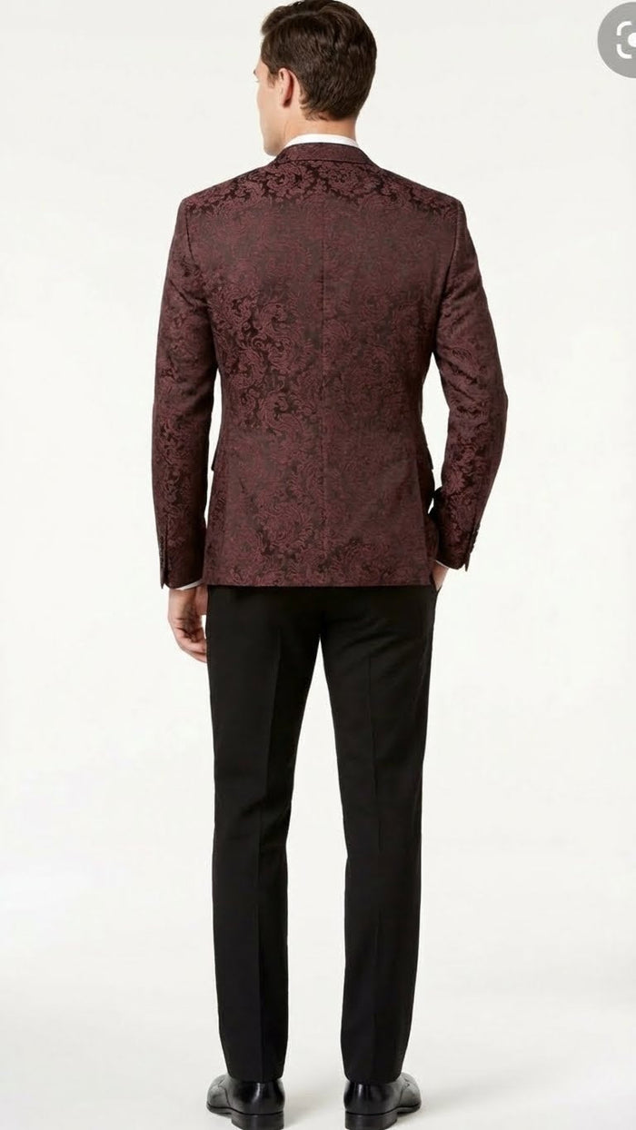 Burgundy paisley velvet blazer with fitted back, single vent, and structured tailoring. Intricate floral pattern. Paired with black trousers for a sophisticated look.
