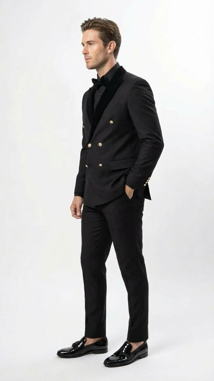Men's black double-breasted tuxedo suit. Tailored silhouette, moderately structured. Gold buttons, velvet lapel. Slim-fit pants. Smooth, solid black fabric. Polished black shoes.
