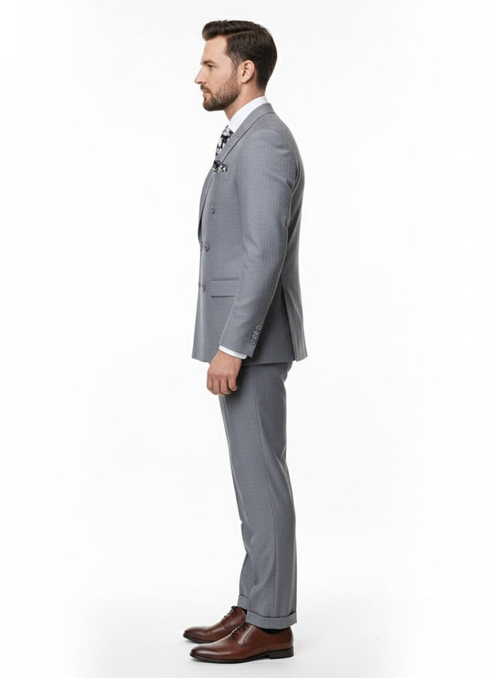 Men's slim fit, grey double-breasted suit. Features a subtle shadow stripe pattern, two-piece design with a tailored jacket and flat front trousers. Made of smooth, light grey material.
