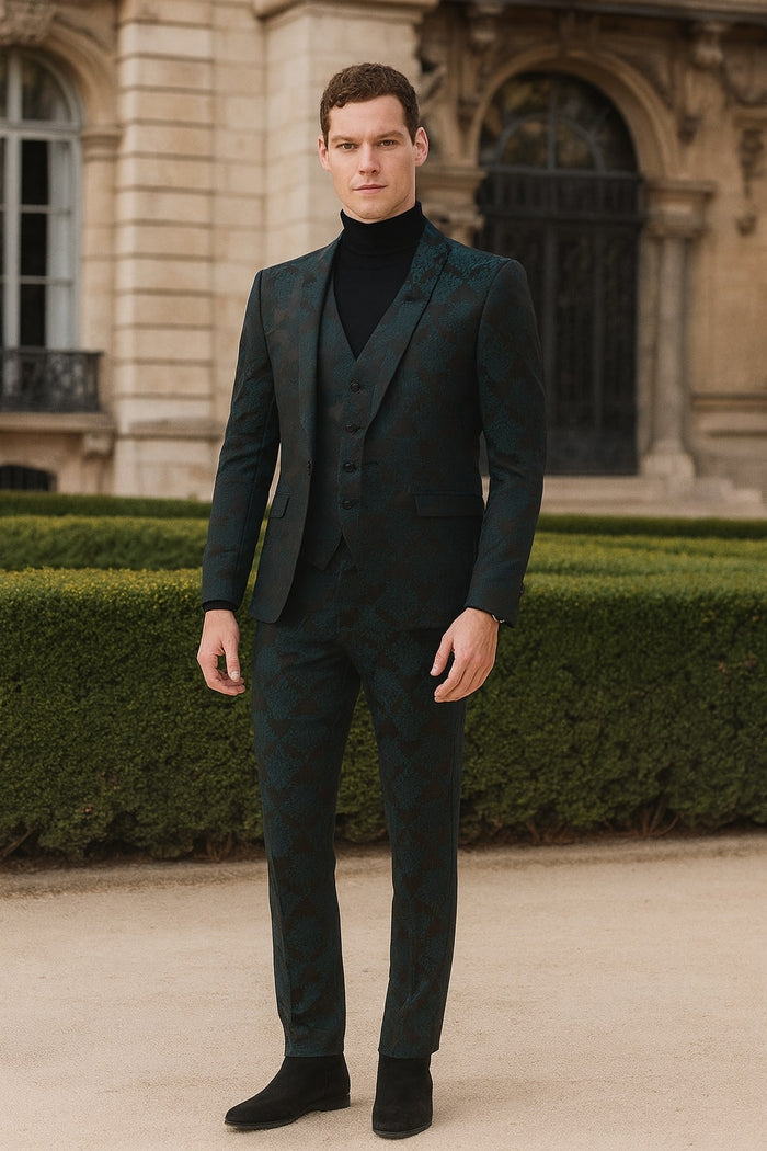 Emerald green floral jacquard 3-piece tuxedo. Fitted jacket with peaked lapels & button closure. Tapered trousers. Rich emerald & dark green hues, textured fabric. Worn with a black turtleneck. Formal wear.