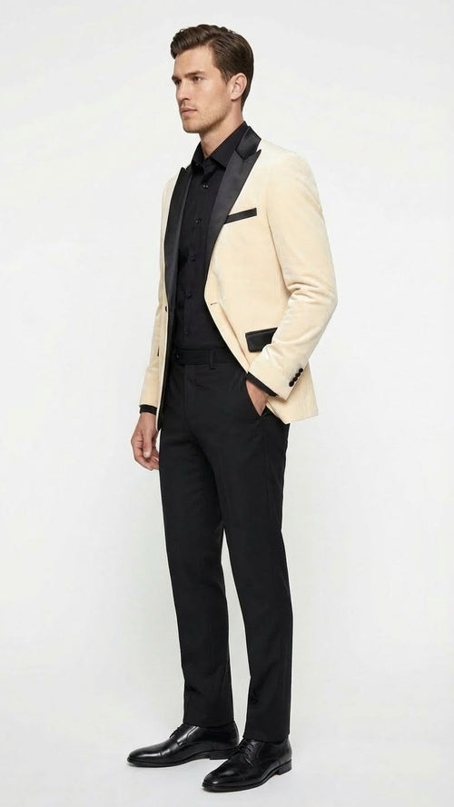 Cream velvet dinner jacket for men, ivory color. Features a black satin lapel, fitted silhouette, single-button closure, and front pocket flaps.
