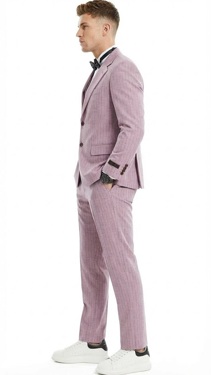 Men's dusty rose pink three-piece suit with pinstripes. Tailored fit includes jacket (brown buttons), trousers (tapered ankles), and vest. Visible stitching.
