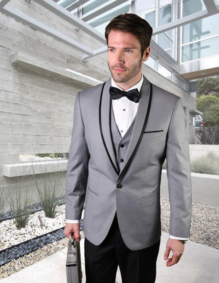 Grey wool tuxedo with shawl lapel and satin trim. Fitted shape with button closure and 3-button vest. Smooth, tailored fabric. Contrasts with dark trousers.