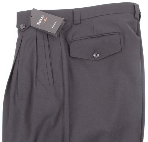 Black Tiglio Luxe wide-leg pants: high-waisted, pleated, pure wool. Features a single back pocket and relaxed silhouette, widening from hips. Sleek, solid black.
