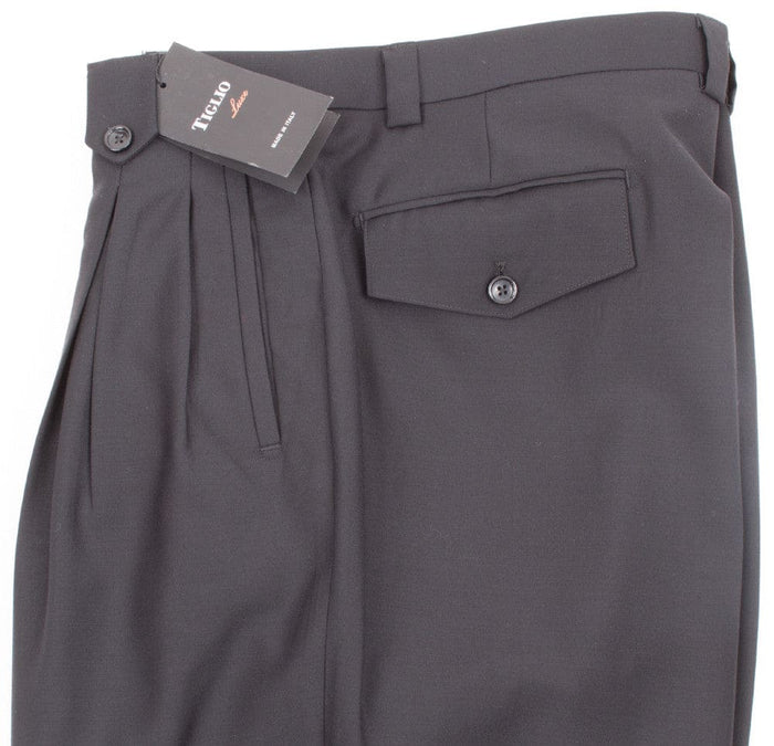 Black Tiglio Luxe wide-leg pants: high-waisted, pleated, pure wool. Features a single back pocket and relaxed silhouette, widening from hips. Sleek, solid black.
