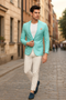 Men's slim-fit aqua blazer. One-button closure, tailored structure, and floral lining. Lightweight turquoise fabric. Stylish and modern design.
