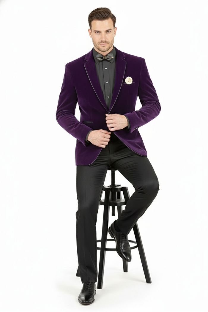 Purple velvet blazer: structured, single-breasted, notched lapels with black trim. Soft, rich texture, vibrant purple. Includes chest pocket, decorative pin. Worn with black shirt and trousers.
