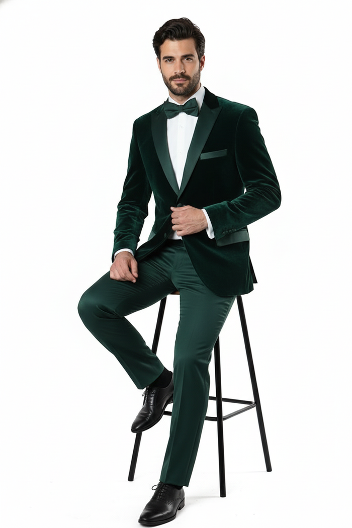 Dark green velvet tuxedo dinner jacket. Tailored fit, single-breasted, notched lapels, left chest pocket. Smooth, luxurious velvet. Deep green hue, black bow tie. Sleek silhouette, tapered waist, padded shoulders.
