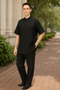 Alberto Nardoni men's black walking suit: short-sleeve, banded collar shirt with button-front and two pockets. Matching straight-leg pants, all in a smooth, solid black fabric.
