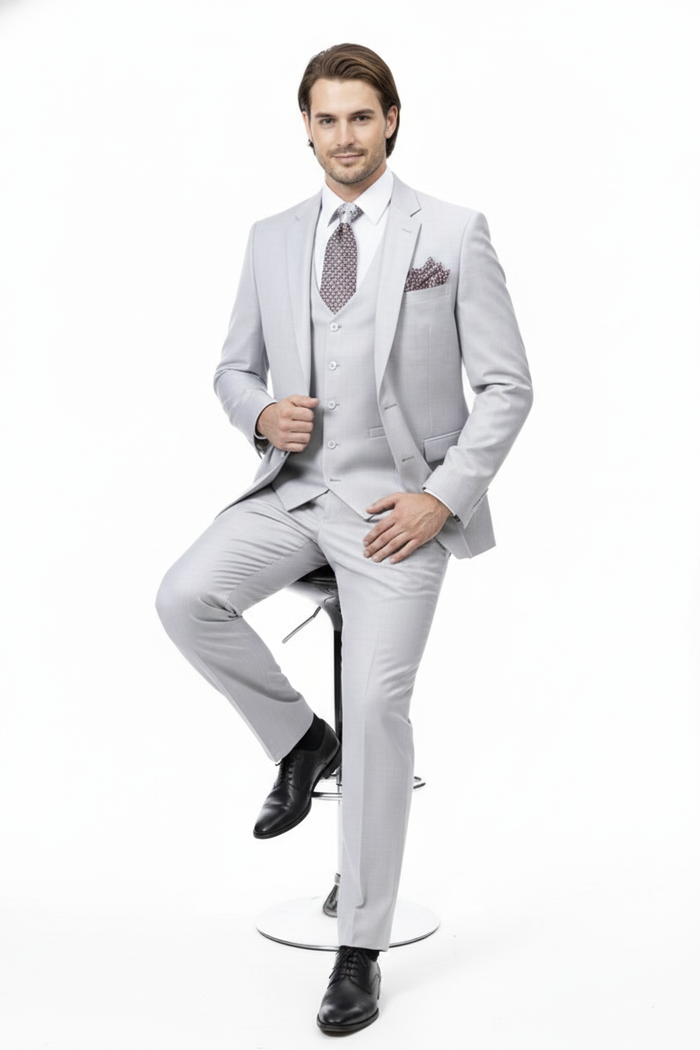 Light gray three-piece wedding suit for men. Two-button jacket, tailored fit, matching vest, slim trousers. Subtle textured fabric. Includes dress shirt, patterned tie, pocket square. Modern, light gray aesthetic.
