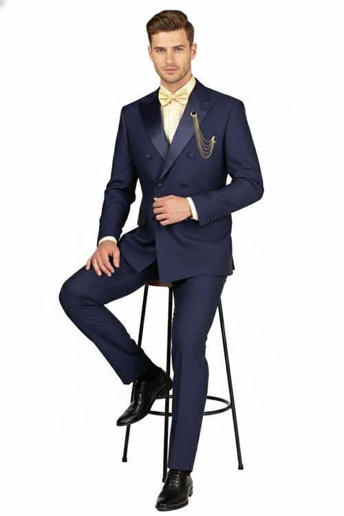 Navy double-breasted tuxedo with satin peak lapels. Features two rows of buttons and matching trousers. Smooth, slightly shiny fabric. Paired with a light shirt and bow tie.
