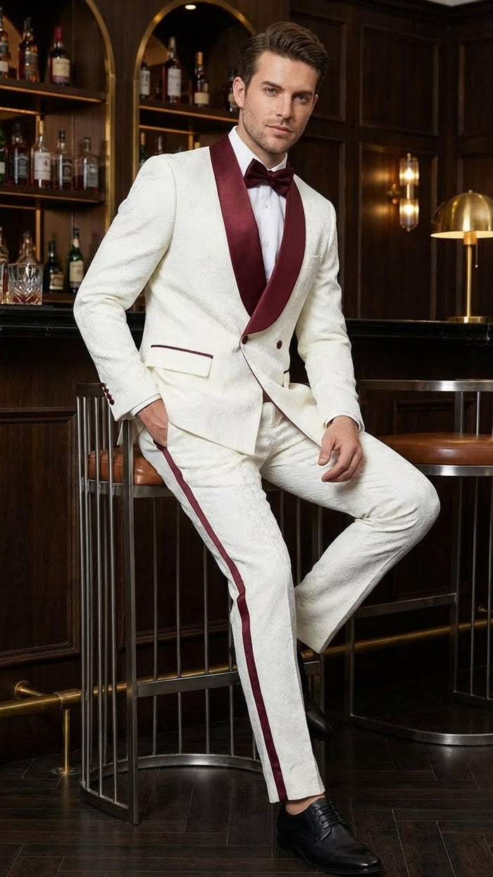 Ivory jacquard tuxedo suit with burgundy shawl collar and patterned fabric. Slim-fit jacket: double buttons, single pocket. Ivory pants with burgundy side stripes.
